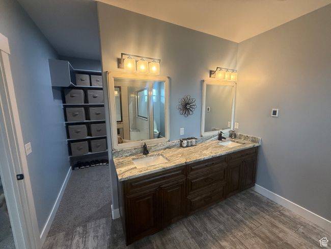 Bathroom featuring wood finished floors, double vanity, and a shower with shower door | Image 61