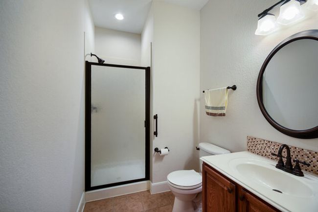 Full bathroom featuring a stall shower, vanity, toilet, tile patterned floors, and baseboards | Image 14