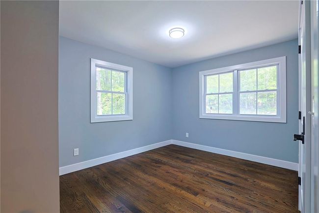 Unfurnished room with a wealth of natural light and dark wood-type flooring | Image 14