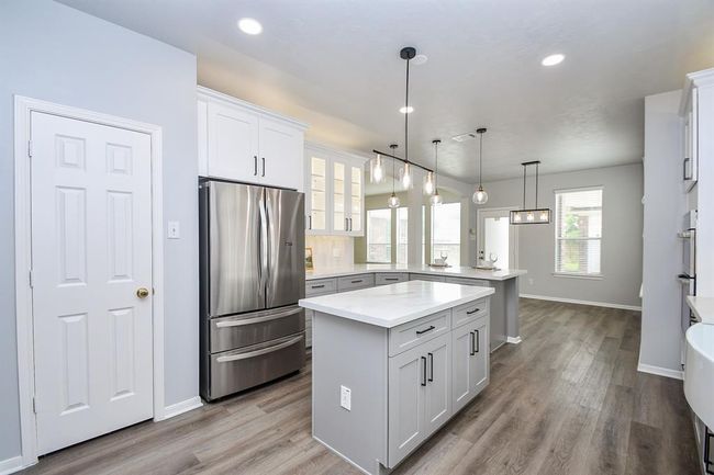You will love cooking in this kitchen, as you whip up your best meals for your favorite people, you can watch your family in the living room and at the breakfast table and backyard- enjoy the life you've built and savor every moment. Note the deep walk-in pantry that follows suit with this glorious kitchen. | Image 12