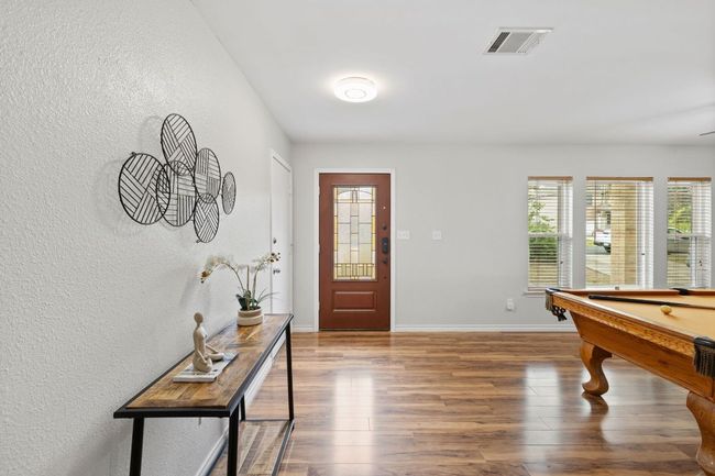 Foyer featuring wood finished floors, baseboards, a textured wall, and pool table | Image 4
