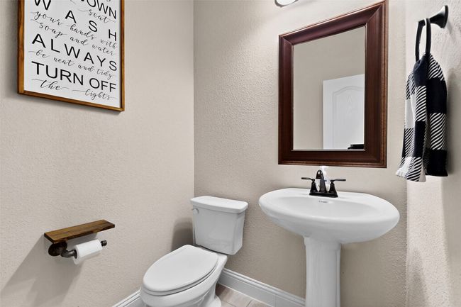 Half bathroom featuring toilet, a sink, and tile patterned floors | Image 29