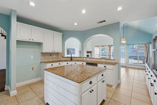Kitchen featuring sink, a kitchen island, light tile patterned flooring, kitchen peninsula, and white cabinets | Image 14