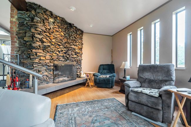 Living room with a glass covered fireplace and wood finished floors | Image 14