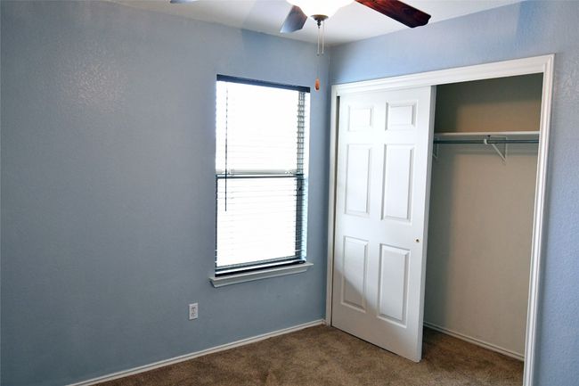 Unfurnished bedroom featuring ceiling fan, multiple windows, carpet, and a closet | Image 19
