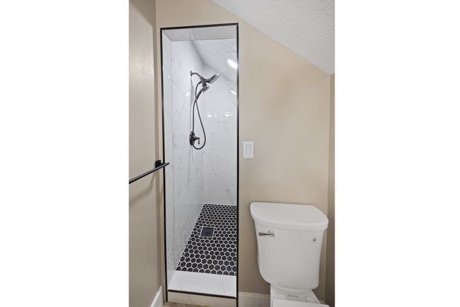 Bathroom featuring a marble finish shower, toilet, and baseboards | Image 54