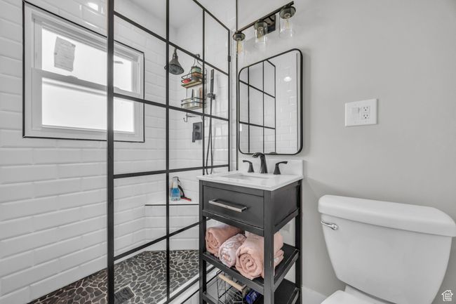 Full bathroom featuring toilet, a tile shower, and vanity | Image 16