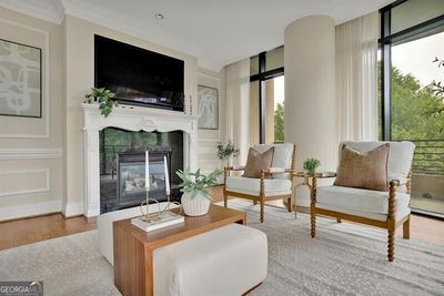 Living room with floor to ceiling windows, wood-type flooring, and ornamental molding | Image 3