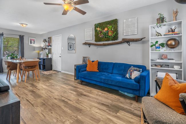 Living area with a ceiling fan, wood finished floors, and baseboards | Image 4