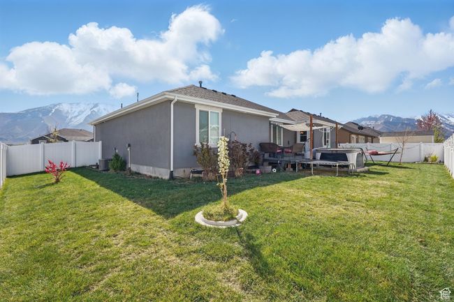 Back of property featuring a yard, stucco siding, a fenced backyard, and a mountain view | Image 50