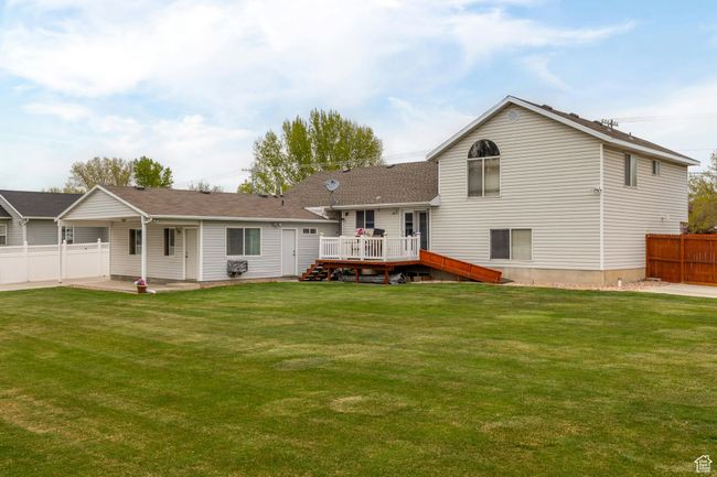 Rear view of property featuring a yard, fence, and a deck | Image 47