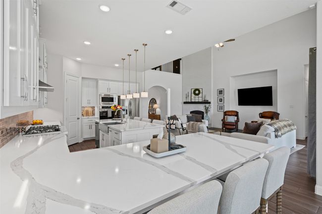 Kitchen with appliances with stainless steel finishes, a sink, arched walkways, open floor plan, and a center island with sink | Image 20
