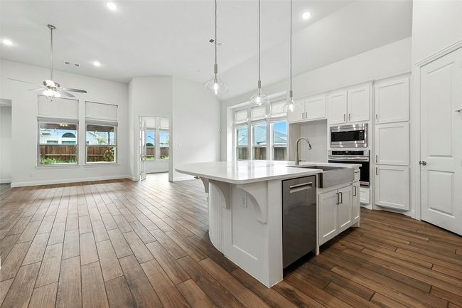 Kitchen featuring open floor plan, recessed lighting, tile floors, ceiling fan, and white cabinetry | Image 5
