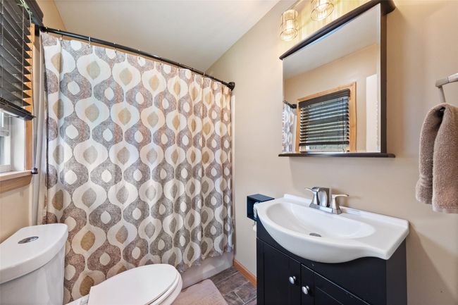 Bathroom featuring toilet, a shower with curtain, and vanity | Image 17