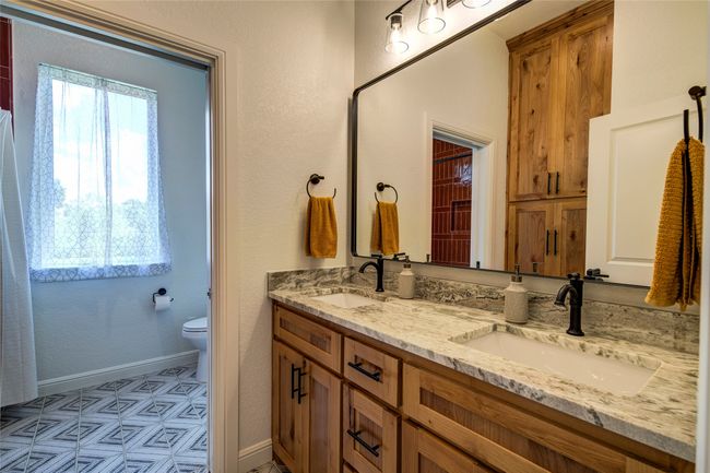 Bathroom with double vanity, toilet, and tile floors | Image 26