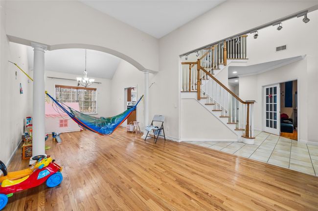 Recreation room with ornate columns, wood-type flooring, visible vents, and arched walkways | Image 4