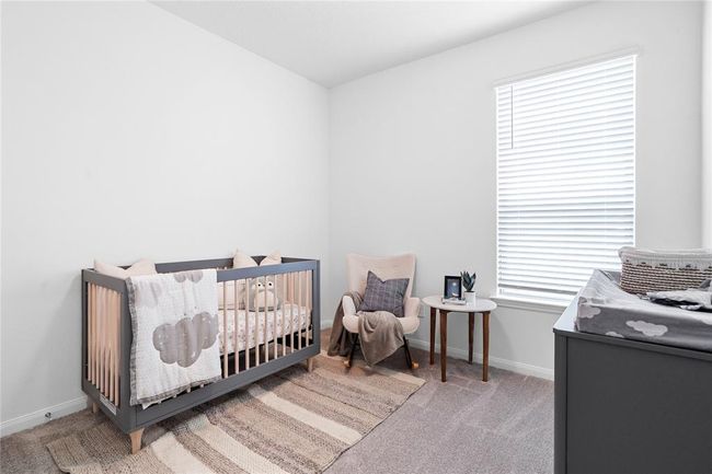 Secondary bedroom features plush carpet, neutral paint, lighting, large window with privacy blinds and ample sized closet space. | Image 8