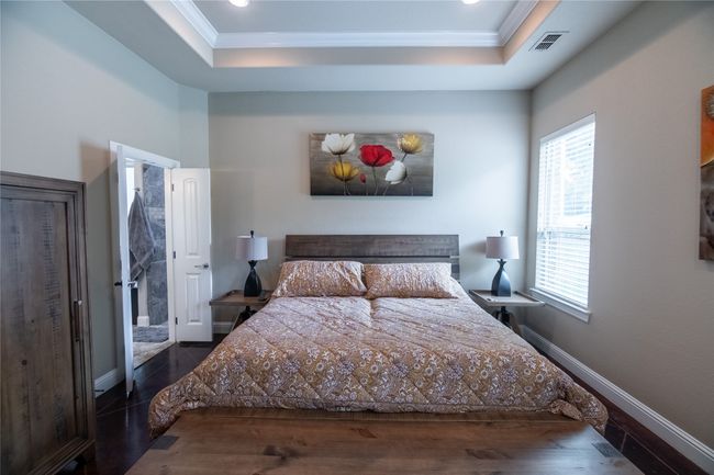 Bedroom with a tray ceiling, ornamental molding, baseboards, recessed lighting, and wood finished floors | Image 19