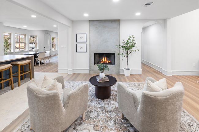 Living area with arched walkways, recessed lighting, wood finished floors, and a fireplace | Image 12