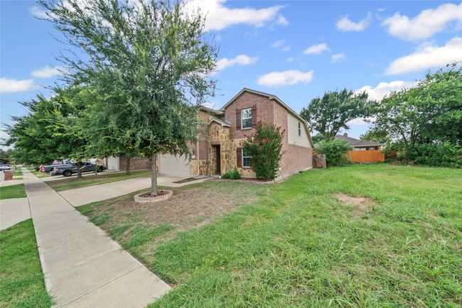 View of front of house with concrete driveway, brick siding, stone siding, and a garage | Image 39