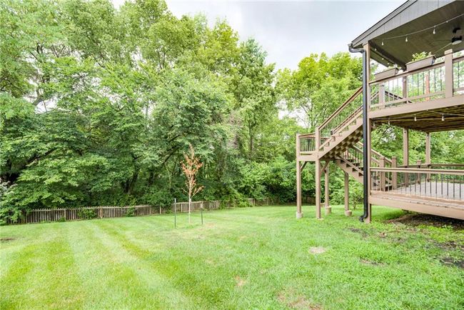 View of yard with a wooden deck, stairs, and view of scattered trees | Image 49