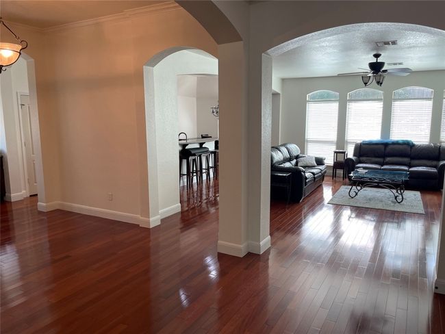 Living room with ceiling fan, arched and crown molding | Image 6