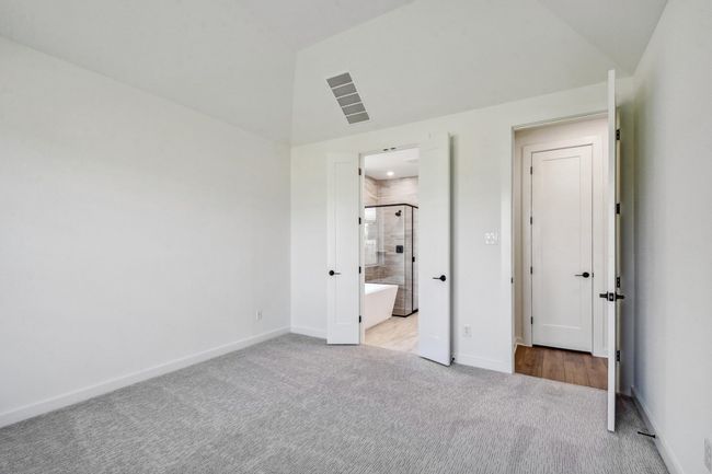 Unfurnished bedroom with carpet, ensuite bath, and high vaulted ceiling | Image 14