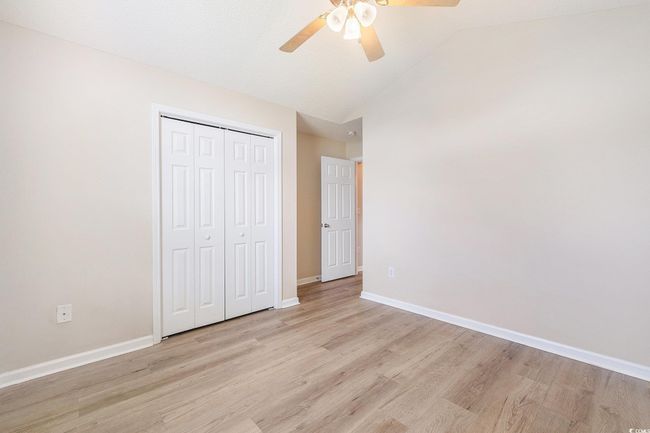 Unfurnished bedroom featuring light wood-style floors, a closet, vaulted ceiling, and a ceiling fan | Image 27