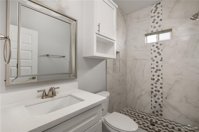 Bathroom featuring vanity, a tile shower, and toilet | Image 9