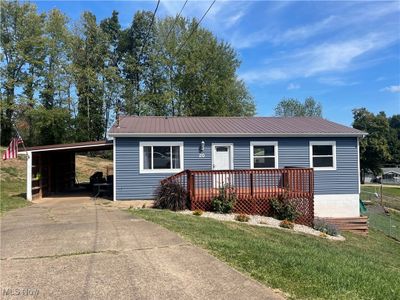 View of front of property with a carport, a deck, and a front yard | Image 1