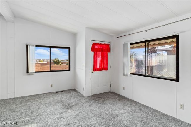 Carpeted living room featuring lofted ceiling, visible vents, and a healthy amount of sunlight | Image 6