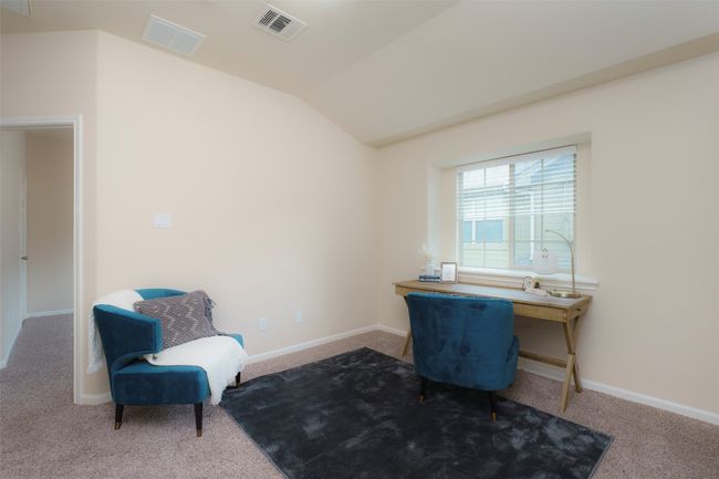 Carpeted home office with baseboards, vaulted ceiling, and visible vents | Image 12