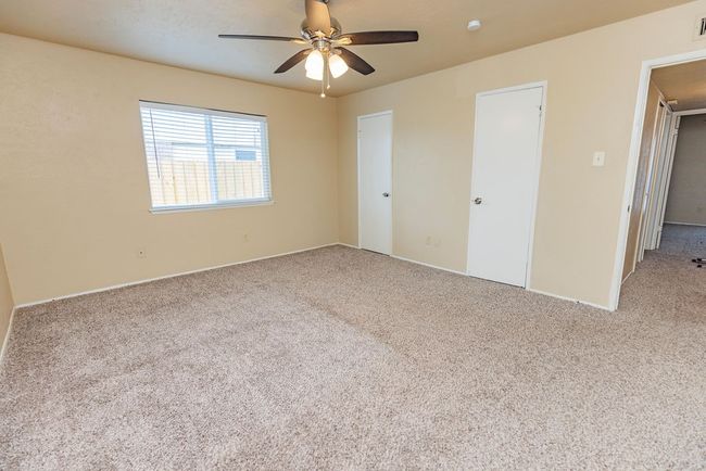 Unfurnished bedroom featuring light colored carpet and ceiling fan | Image 14