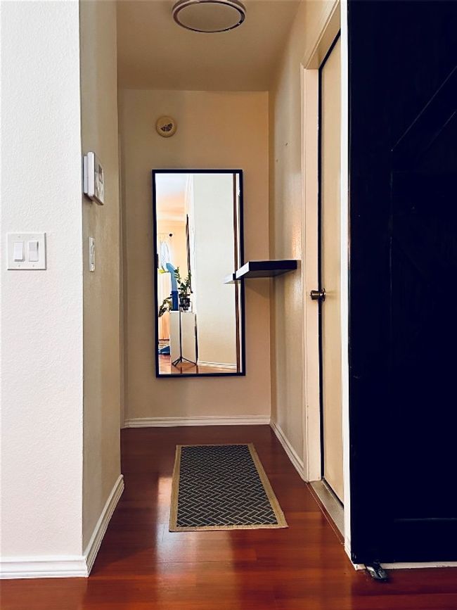 Hallway with visible vents, baseboards, and wood finished floors | Image 12