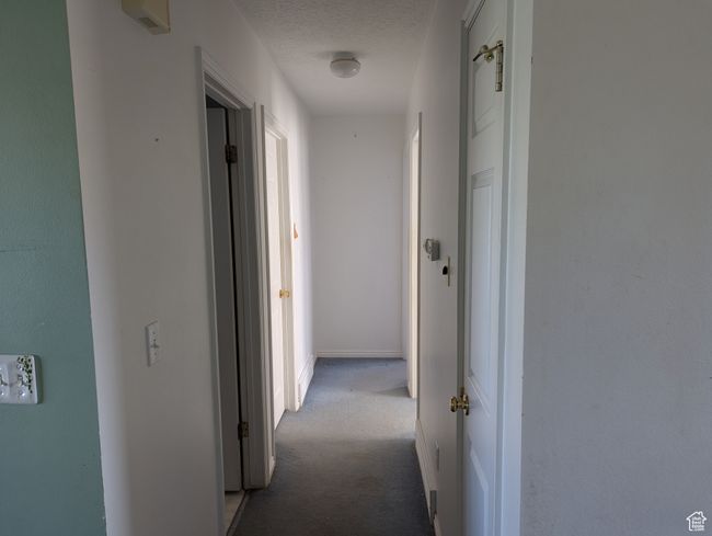 Hall featuring carpet and a textured ceiling | Image 4