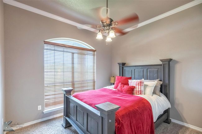 Carpeted bedroom featuring multiple windows, ornamental molding, baseboards, and a ceiling fan | Image 21