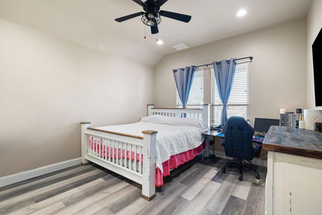 Bedroom featuring visible vents, vaulted ceiling, wood finished floors, and baseboards | Image 18