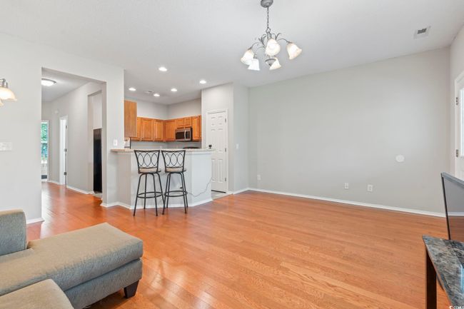 Living room with a chandelier, light wood-type flooring, baseboards, and recessed lighting | Image 6