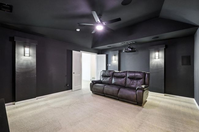 Cinema featuring a ceiling fan, lofted ceiling, and carpet | Image 25