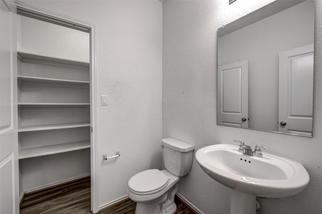 Half bathroom with wood finished floors, toilet, and a sink | Image 13
