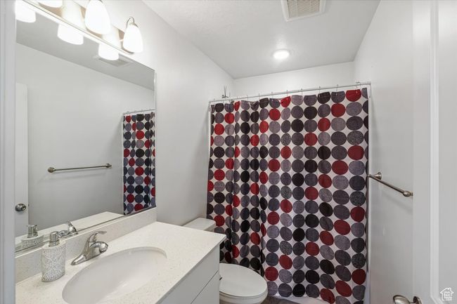 Full bath with visible vents, toilet, a shower with shower curtain, and vanity | Image 17