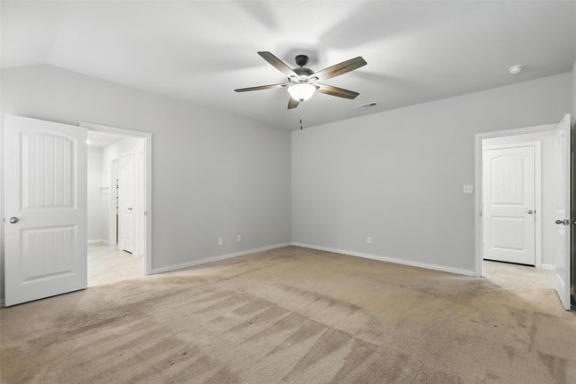 Unfurnished bedroom featuring light carpet, baseboards, a ceiling fan, and lofted ceiling | Image 12