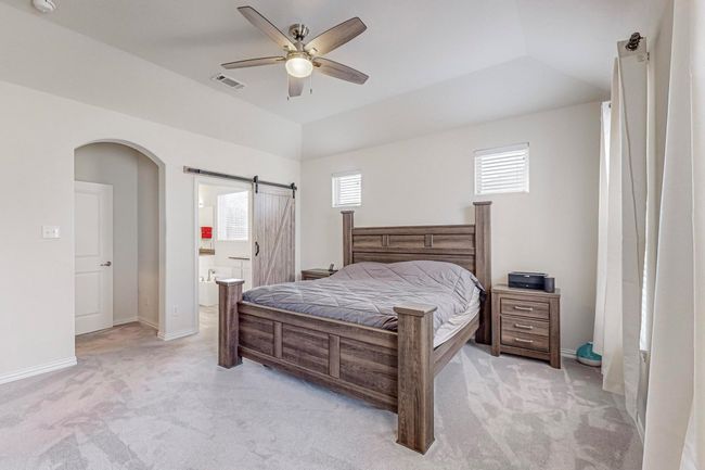 Bedroom with multiple windows, light carpet, arched walkways, baseboards, and vaulted ceiling | Image 31