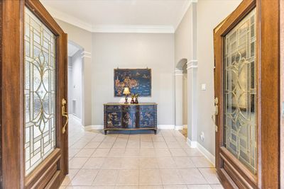 Double doors lead into to the open-concept layout greeting you with beautiful natural light, architecturally pleasing archways, high ceilings, and a neutral palette throughout. | Image 3