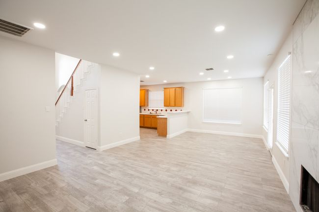 Unfurnished living room featuring light wood-type flooring, stairway, and recessed lighting | Image 18