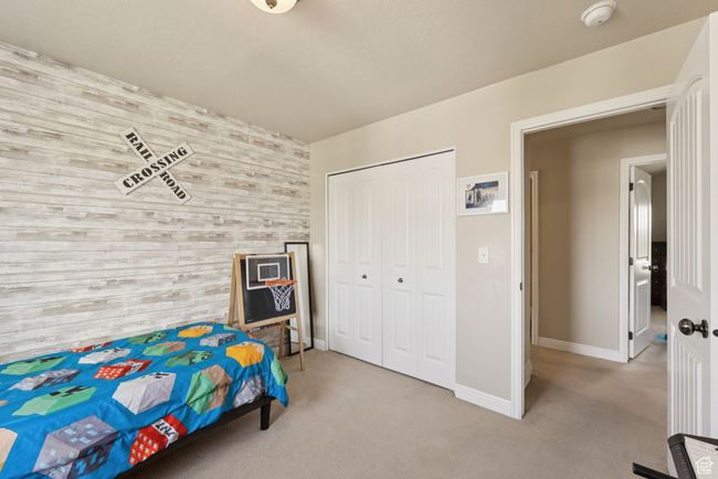 Bedroom featuring an accent wall, wood walls, carpet, and a closet | Image 31