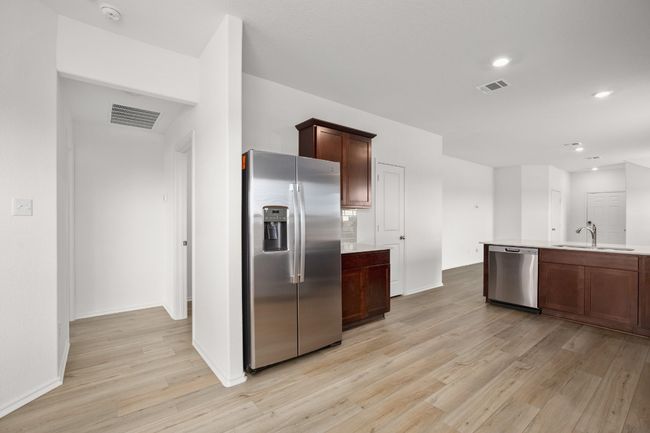 Kitchen with appliances with stainless steel finishes, a sink, light wood-style flooring, light countertops, and recessed lighting | Image 8