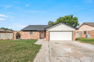 View of front of house featuring a front lawn, central AC, and a garage | Image 1