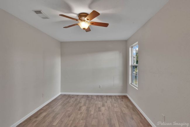 Unfurnished room with ceiling fan and light wood-type flooring | Image 13