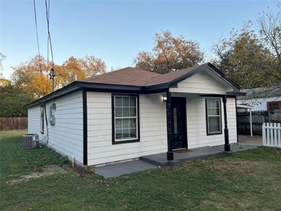 Bungalow with a front yard and cooling unit | Image 1